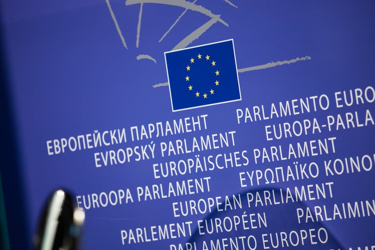 Bandera de la Unión Europea junto a símbolos de regulación y tecnología representando el AI Act