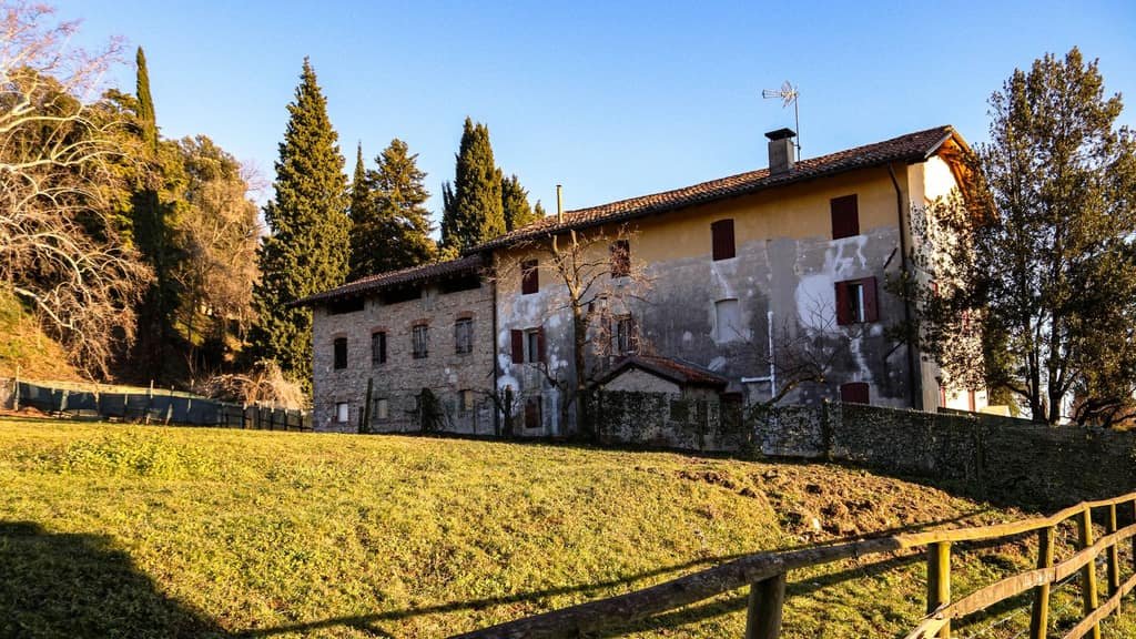 Casa rural de piedra rodeada de campo